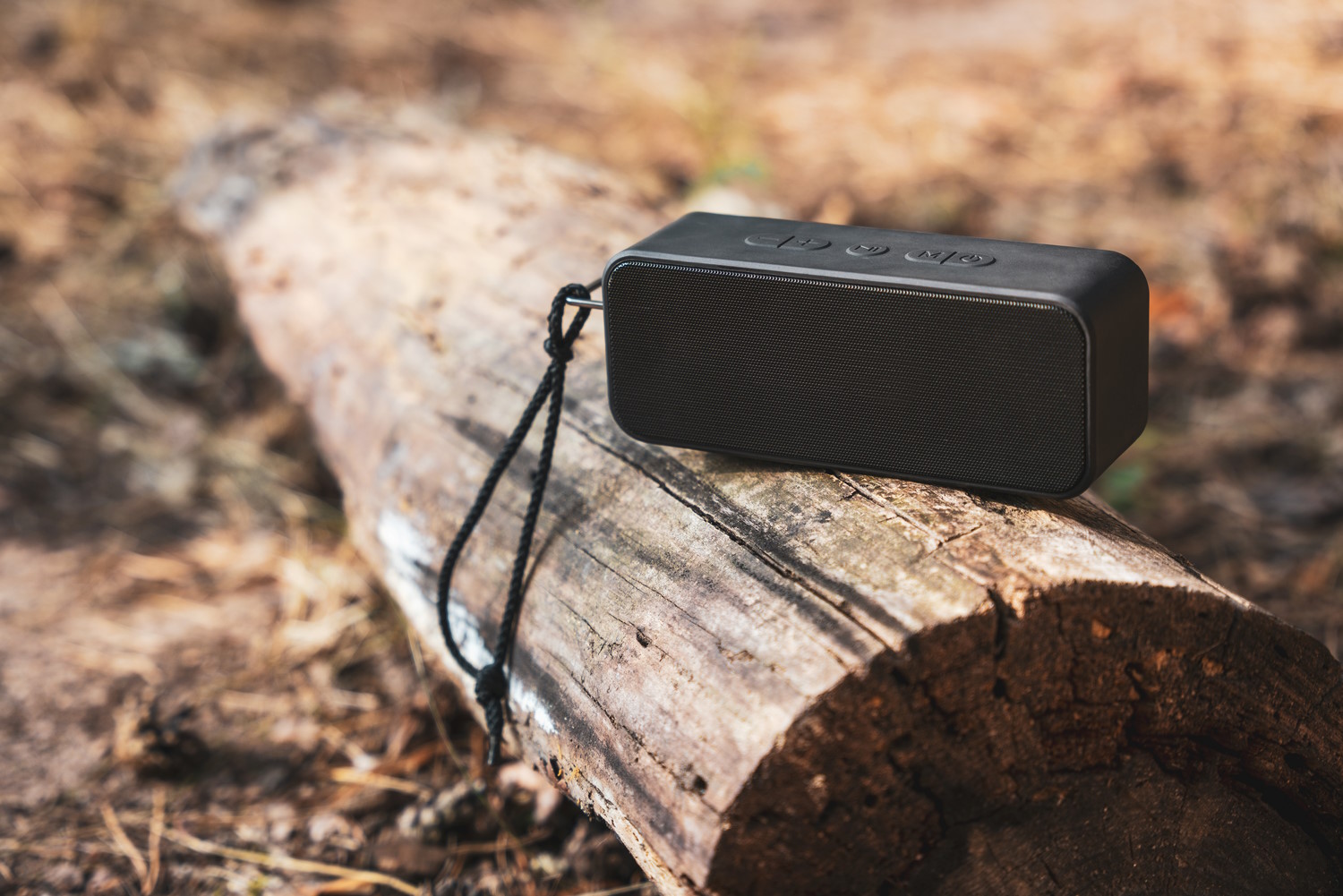 altavoz portatil bluetooth en un tronco